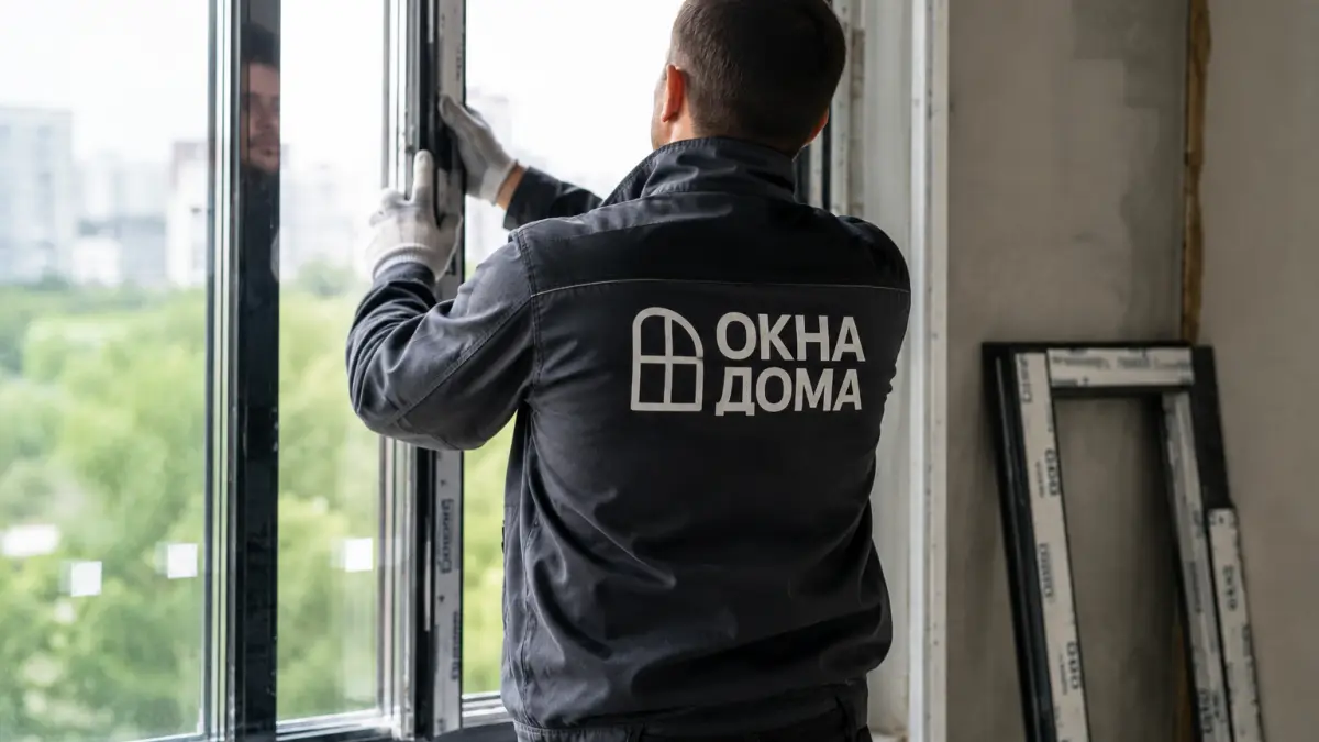 Монтажник ОкнаДома устанавливает окно